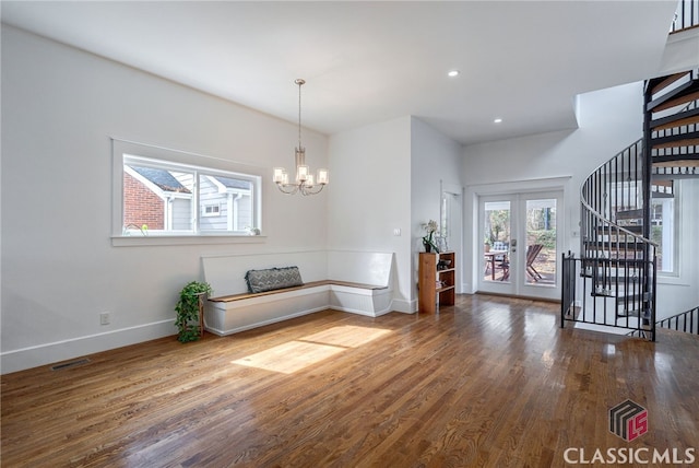 interior space featuring baseboards, visible vents, stairway, wood finished floors, and french doors