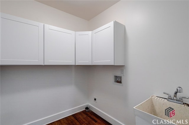 laundry room with hookup for a washing machine, a sink, baseboards, cabinet space, and dark wood-style floors