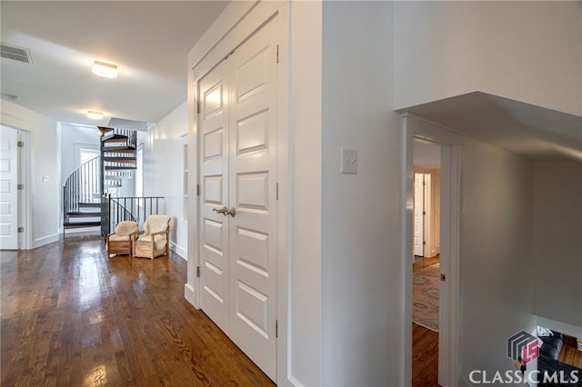 hallway featuring baseboards, stairs, visible vents, and dark wood-type flooring