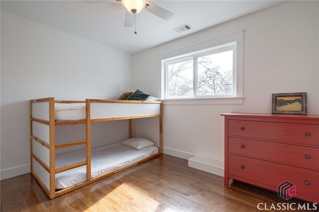 unfurnished bedroom with wood finished floors, visible vents, and baseboards