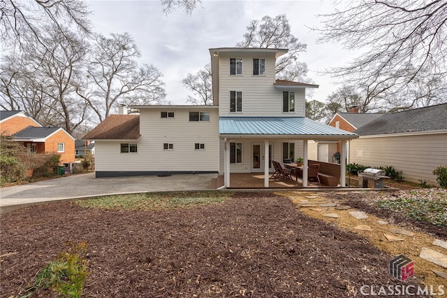 back of property featuring metal roof and a patio