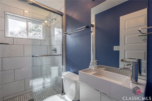 bathroom featuring toilet, a stall shower, and vanity