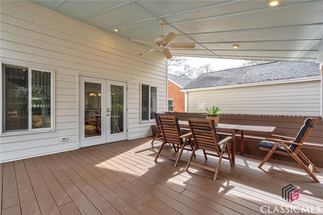 wooden terrace with a ceiling fan, outdoor dining space, and french doors