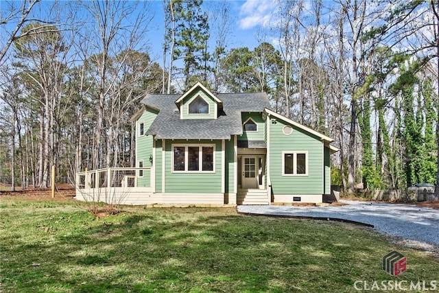 view of front of home with roof with shingles and a front yard