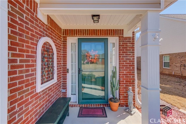 doorway to property featuring brick siding