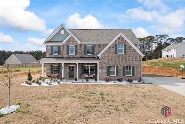 craftsman inspired home with a porch, a front yard, and brick siding