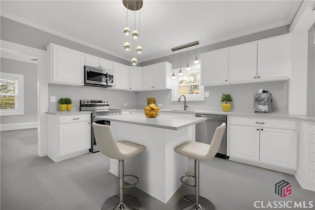 kitchen with stainless steel appliances, light countertops, a breakfast bar area, and white cabinetry