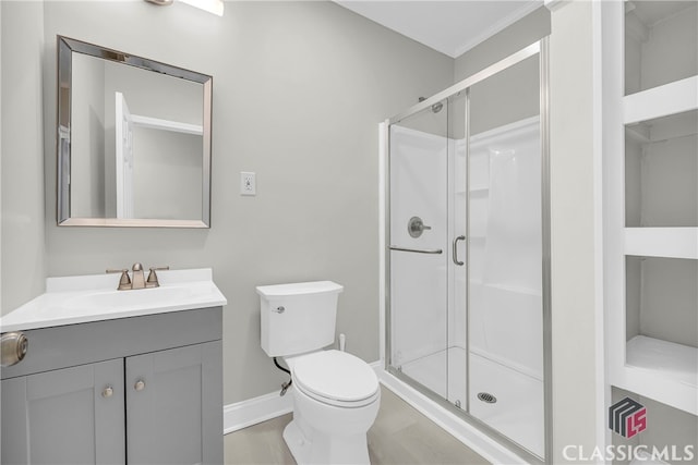 full bath featuring a stall shower, baseboards, vanity, and toilet