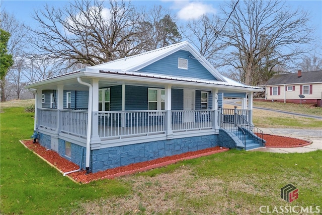 view of front of home with metal roof, a porch, and a front lawn