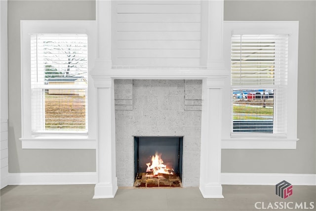 interior details with a lit fireplace and baseboards