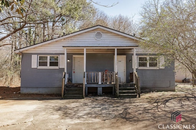 view of front of home featuring covered porch and concrete block siding