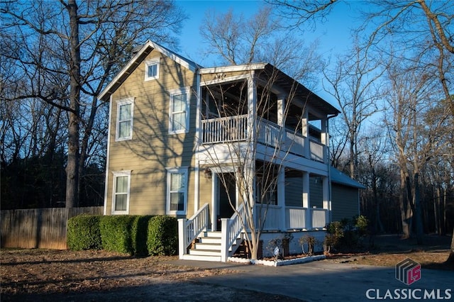 view of front of property with fence and a balcony