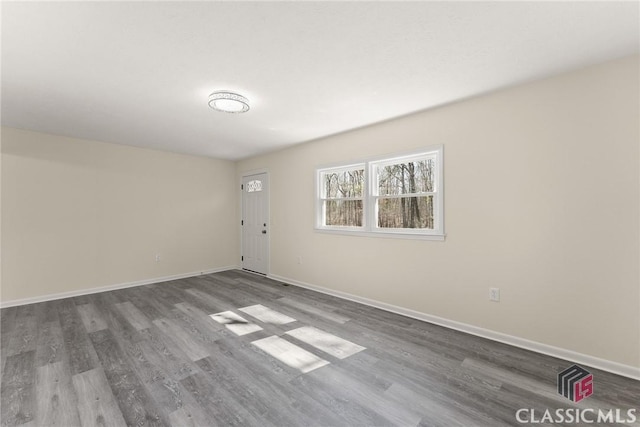 unfurnished room featuring baseboards and wood finished floors