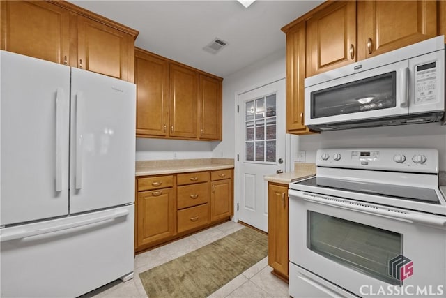 kitchen with light countertops, white appliances, brown cabinetry, and visible vents