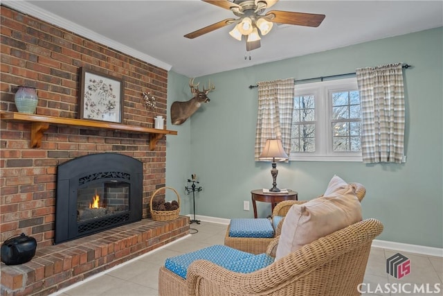 sitting room featuring light tile patterned floors, ceiling fan, a fireplace, and baseboards