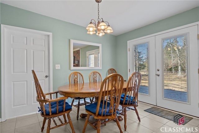 dining area featuring french doors, light tile patterned flooring, and an inviting chandelier