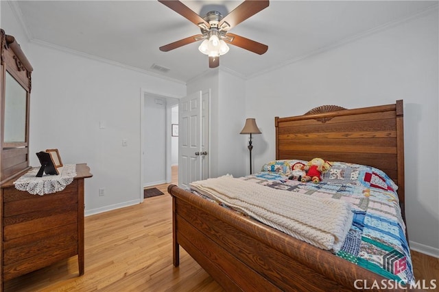 bedroom featuring light wood-style flooring, visible vents, baseboards, and crown molding