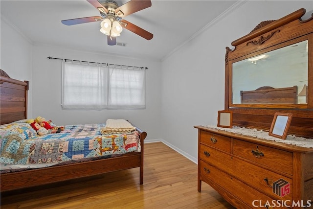 bedroom with crown molding, light wood finished floors, visible vents, ceiling fan, and baseboards