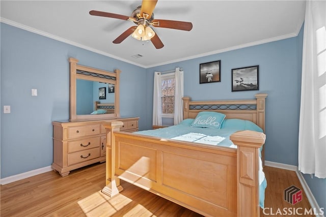 bedroom featuring a ceiling fan, crown molding, light wood-style flooring, and baseboards