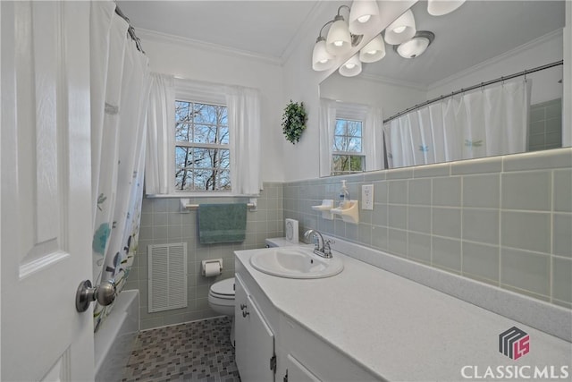 full bath featuring visible vents, toilet, crown molding, vanity, and tile walls