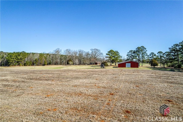 view of yard with a rural view and a detached garage