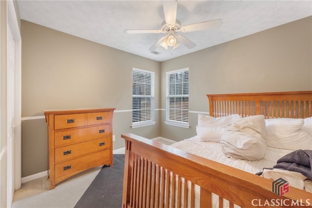 bedroom featuring visible vents, light carpet, ceiling fan, a textured ceiling, and baseboards