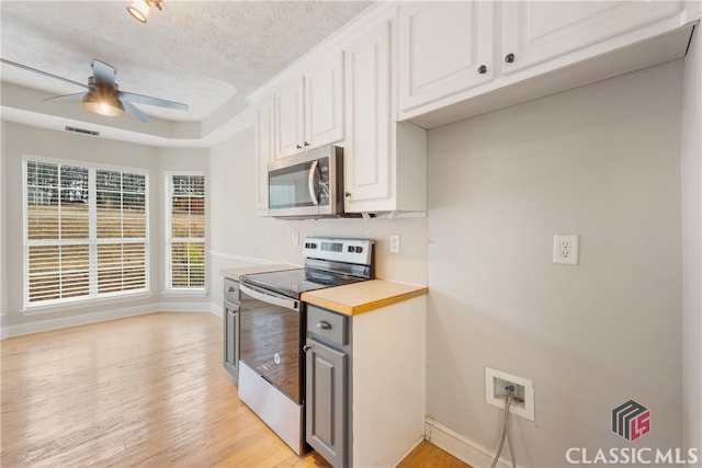 kitchen with ceiling fan, visible vents, white cabinets, light countertops, and appliances with stainless steel finishes