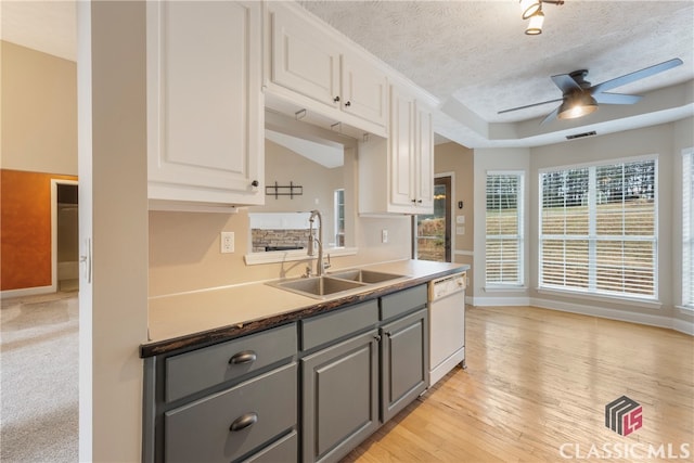 kitchen featuring white cabinets, a ceiling fan, dishwasher, gray cabinetry, and a sink