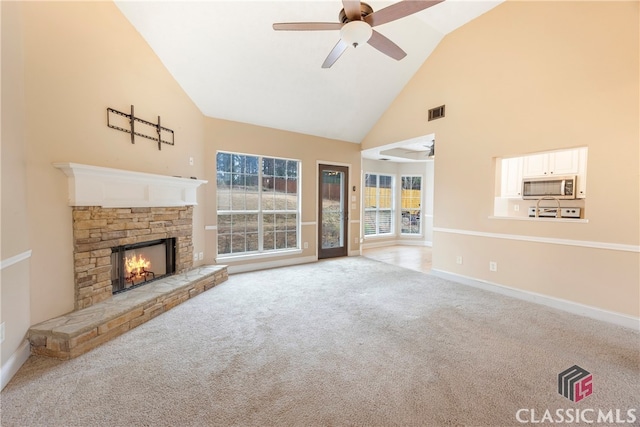 unfurnished living room with baseboards, a ceiling fan, carpet floors, a fireplace, and high vaulted ceiling