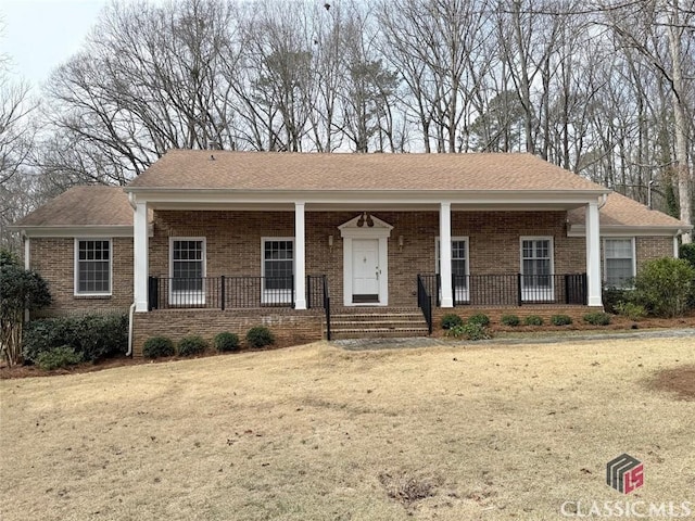 ranch-style home with a porch, brick siding, and a front lawn