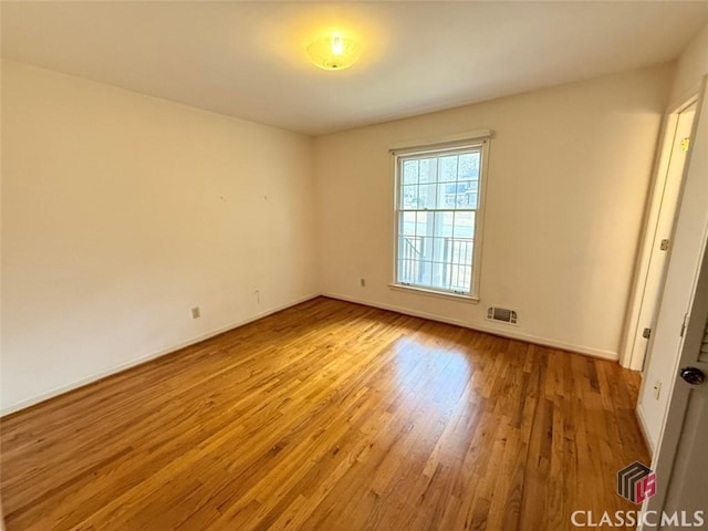 unfurnished room with baseboards, visible vents, and light wood-style floors