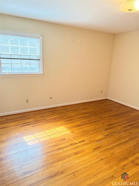 empty room featuring light wood-type flooring and baseboards