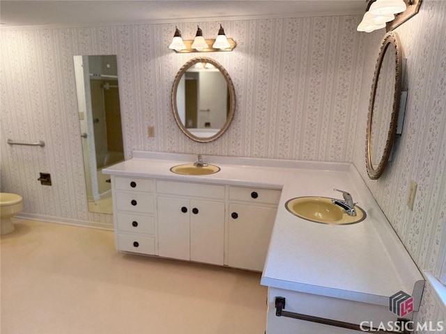 full bathroom featuring double vanity, wallpapered walls, and a sink