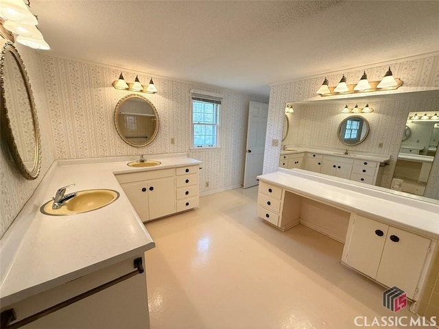 full bathroom with wallpapered walls, a textured ceiling, and a sink