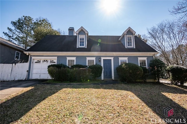 cape cod house with a chimney, an attached garage, fence, driveway, and a front lawn