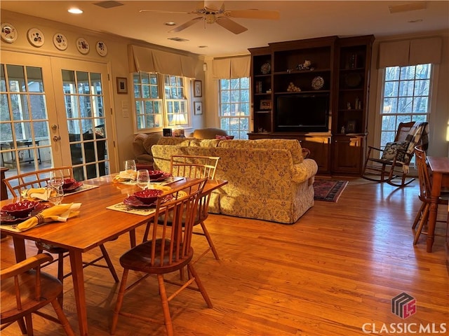 dining room with visible vents, ceiling fan, ornamental molding, french doors, and light wood-type flooring