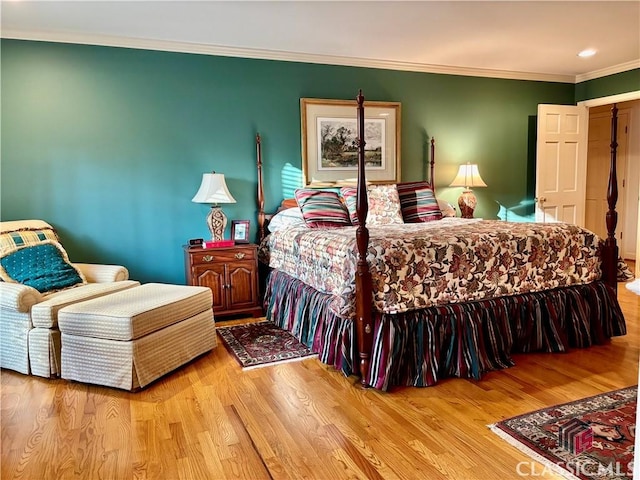 bedroom featuring ornamental molding and wood finished floors