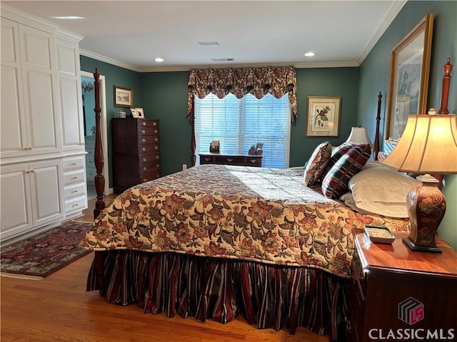 bedroom featuring ornamental molding, wood finished floors, visible vents, and recessed lighting