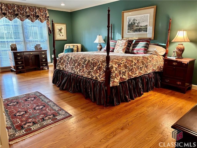 bedroom with crown molding and wood finished floors