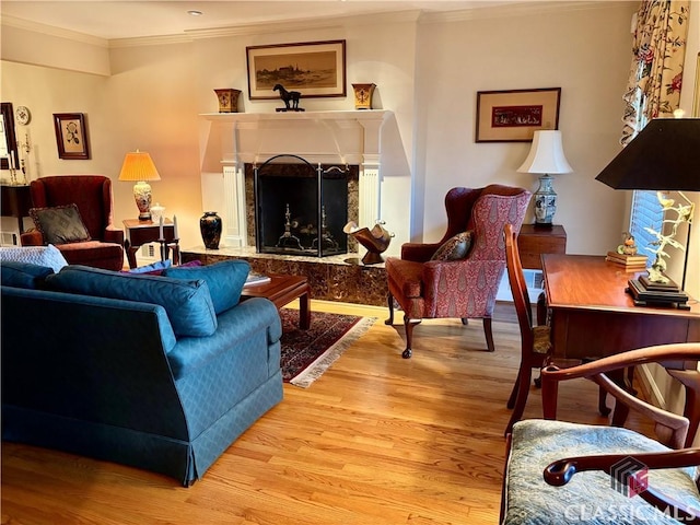 living room with light wood-style floors, a fireplace, and crown molding