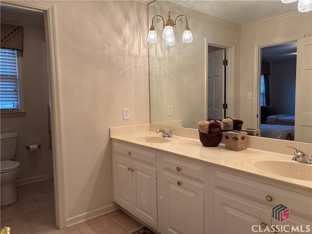 ensuite bathroom featuring toilet, ornamental molding, a sink, and tile patterned floors