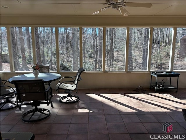 sunroom / solarium featuring a ceiling fan and a healthy amount of sunlight