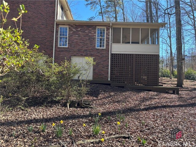 view of side of home featuring a sunroom and brick siding