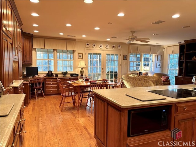 kitchen featuring french doors, light wood finished floors, recessed lighting, visible vents, and black appliances