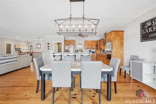 dining area with ceiling fan with notable chandelier, ornamental molding, recessed lighting, and light wood-style floors