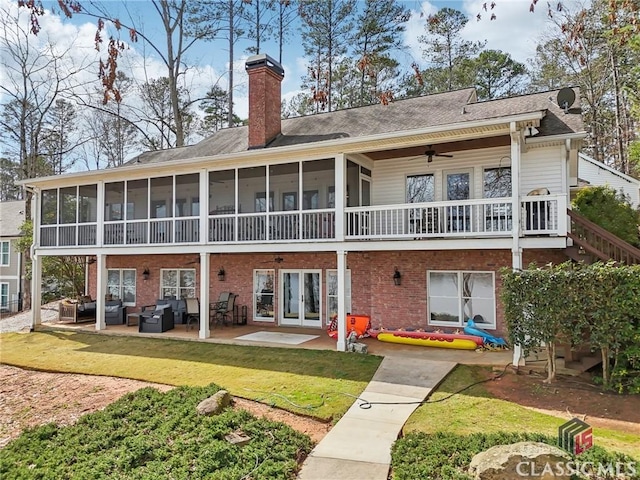 back of house with a chimney, an outdoor hangout area, a sunroom, a patio area, and ceiling fan