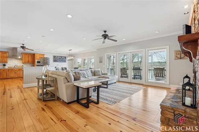 living area featuring a ceiling fan, recessed lighting, crown molding, and light wood finished floors