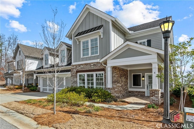 view of front facade featuring board and batten siding, brick siding, driveway, and a garage