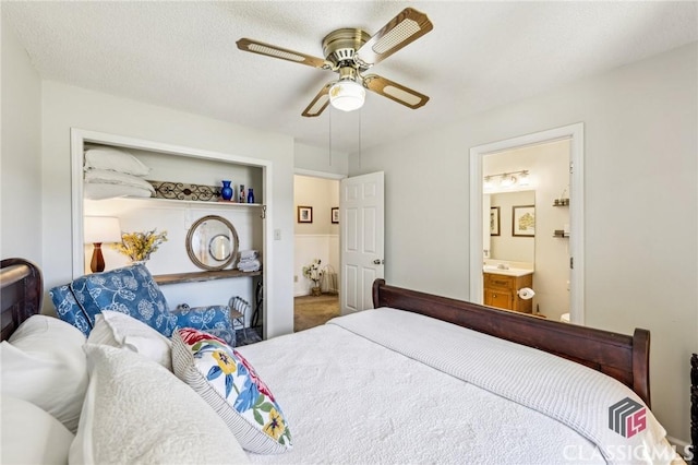 bedroom featuring a textured ceiling, ceiling fan, and ensuite bathroom