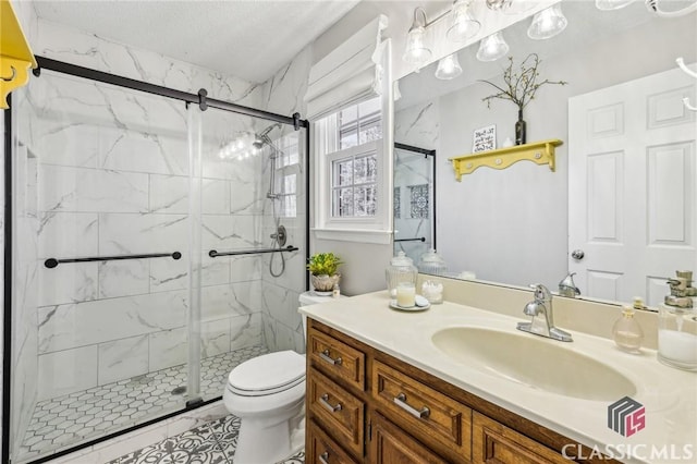 full bath with toilet, a shower stall, a textured ceiling, and vanity